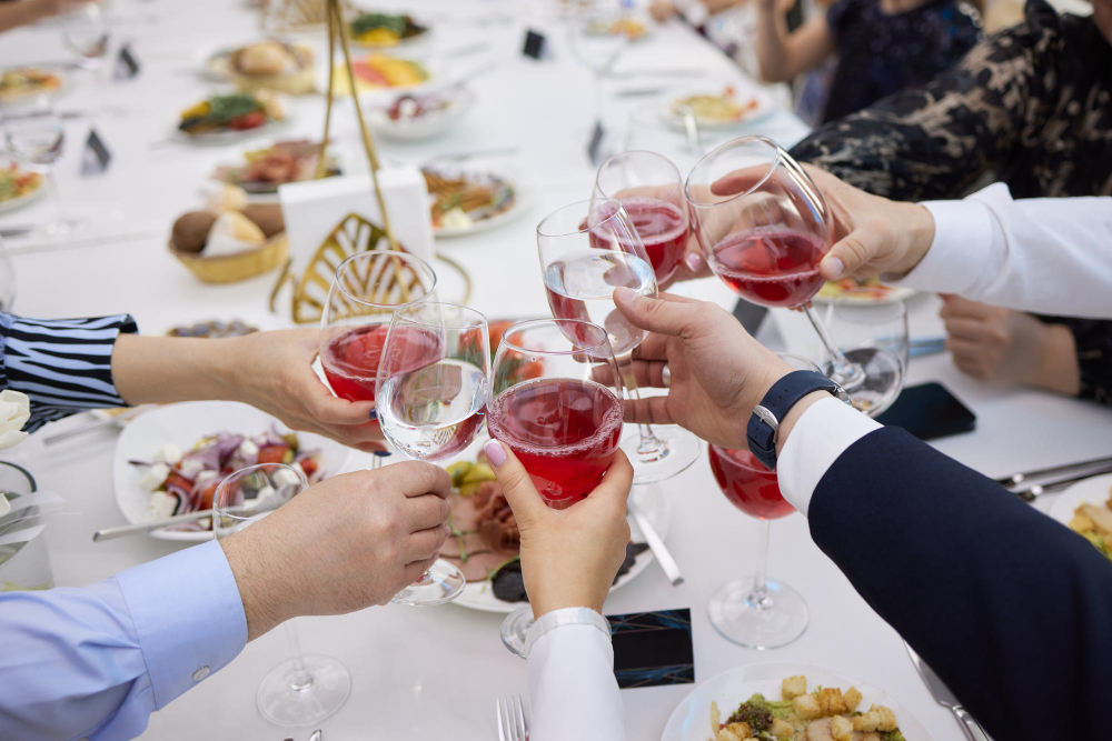 Świętowanie z kieliszkami alkoholu w dłoniach. Szczęśliwe przyjaciółki dobrze się bawią.